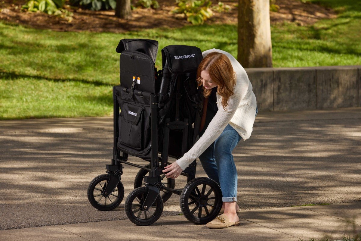 A woman folding a W4 Luxe Pro in a park.